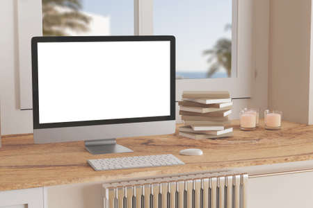 Blank computer desktop with keyboard on table at window, books on marble table in sunny room, mockupの写真素材