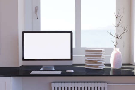 Blank computer desktop with keyboard on table at window, books on marble table in sunny room, mockupの写真素材