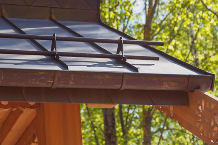 Close up view of fastening metal snow retainer on copper roof