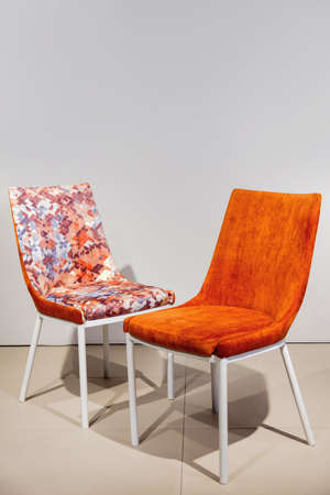 Orange contemporary armchairs with velour upholstery and white metal legsの写真素材