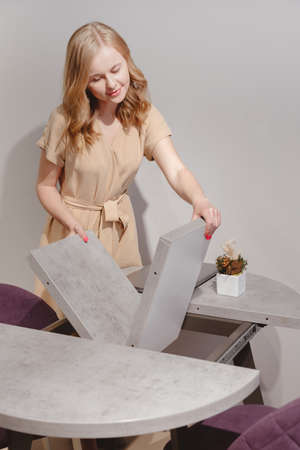 Woman setting up extendable dining table.の写真素材