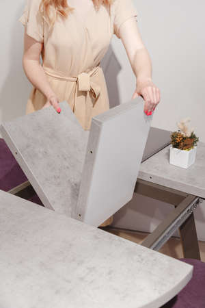 Woman setting up extendable dining table.の写真素材
