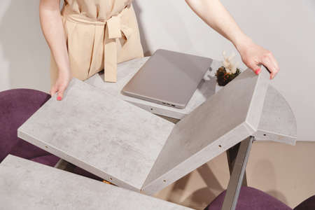 Woman setting up extendable table.の写真素材
