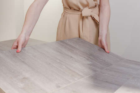 Woman mounting new white furniture, she putting a tabletop on a new half assembled dressing table.の写真素材