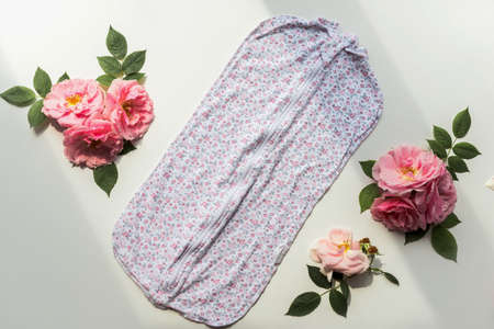 Newborn romper with a flower pattern and roses composition. Isolated on white backgroundの写真素材