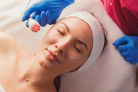 Facial Beauty Treatment. Woman Doing Red Led Light Therapyの写真素材