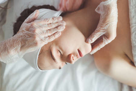 Doctor examining young woman face before cosmetic proceduresの写真素材