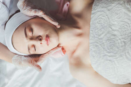 Doctor examining young woman face before cosmetic proceduresの写真素材