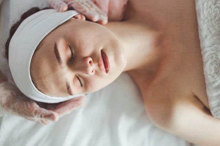 Doctor examining young woman face before cosmetic proceduresの写真素材