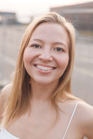 Caucasian girl smiling with dental braces, standing outdoorsの写真素材