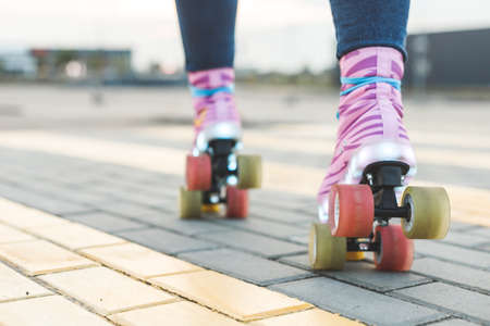 Young woman legs riding on colorful roller-skates. Back bottom viewの写真素材