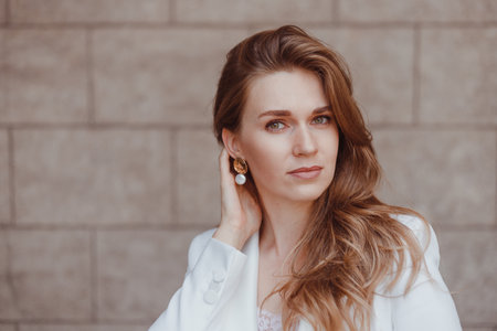 Business woman in white suit posing outdoors.の写真素材