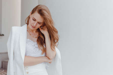 Elegant young woman portrait in while fashion look outdoorsの写真素材