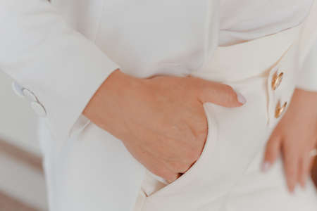 Woman in white pants holds hand in pocketの写真素材