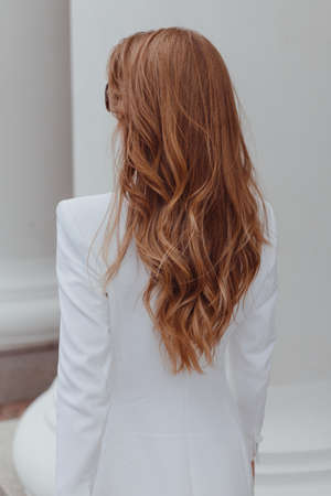 Beauty girl with brown curly hair. Healthy and long brown wavy hair. Beautiful young woman. Rear viewの写真素材