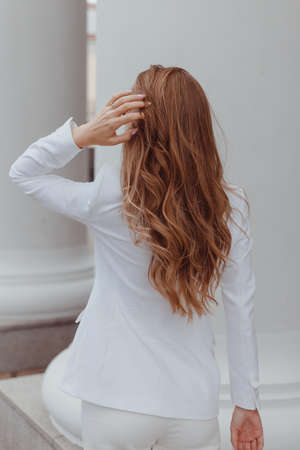 Beauty girl with brown curly hair. Healthy and long brown wavy hair. Beautiful young woman. Rear viewの写真素材