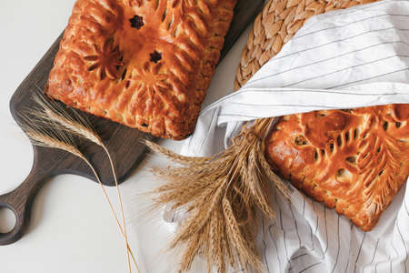 Homemade baked pies with mushrooms and berry cake cooling on cloth with copy space. Flat lay, top viewの写真素材