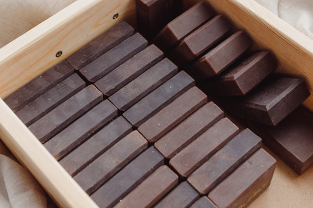 Handmade soap bars batch in wooden box. Deep brown color men solid soaps. Concept animal fat free,...