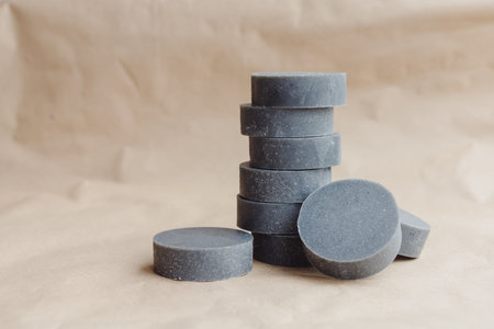 Stack of handmade solid shampoo and conditioner bars on paper background. Copy space for text