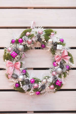 Christmas wreath of pine branches with cones on white wooden background, Christmas balls, copy space.の写真素材