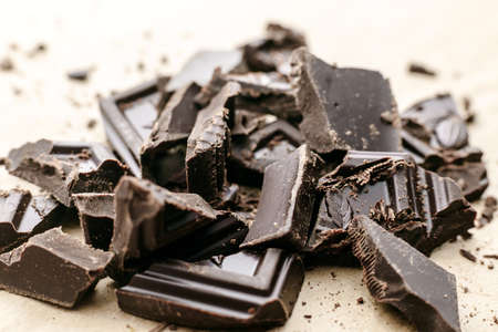 Broken to pieces dark chocolate, crushed and powder pieces. close up view, macro photoの写真素材