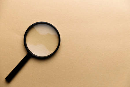 golden magnifier on yellow paper backgroundの写真素材