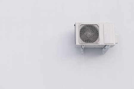 Outdoor air conditioner split system unit on white wall with copy space. HVAC industrial applianceの写真素材