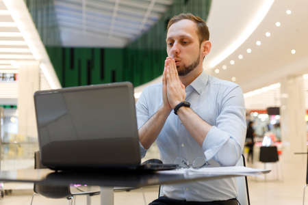 Young businessman practicing breathing exhalation exercises working online to manage stress and calm down. support workerの写真素材