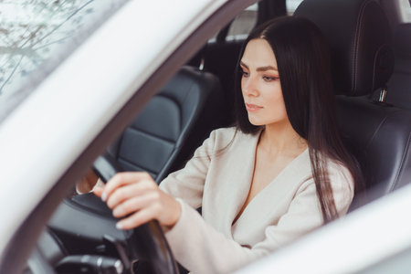 Young brunette european concentrated woman driving car looking at roadの写真素材