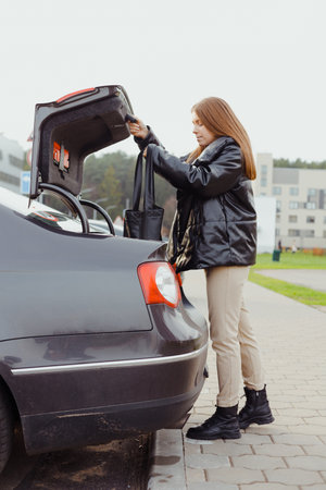 woman puts her purchases in car trunkの写真素材