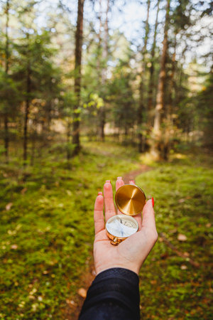 Hand with compass in forest terrain. POV travel concept.の写真素材