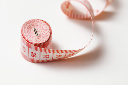 Tape Measure Rolled Isolated on White with Copyspace. Fitness, sewing measuring conceptの写真素材