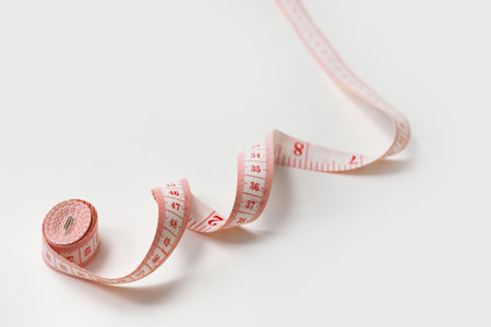 Tape Measure Rolled Isolated on White with Copyspace. Fitness, sewing measuring conceptの写真素材