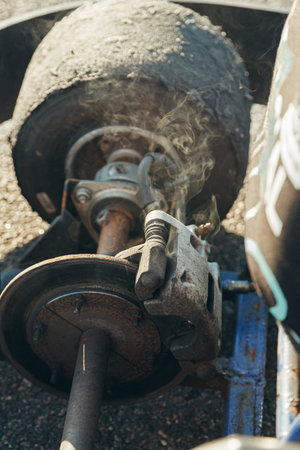Brake disc smokes from overheating with brake caliper, go-kart racing sport.