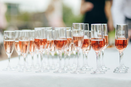 Glasses with red and pink wine, outdoor wedding buffet, white tableの写真素材