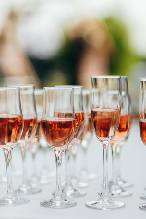 Glasses with red and pink wine, outdoor wedding buffet, white tableの写真素材