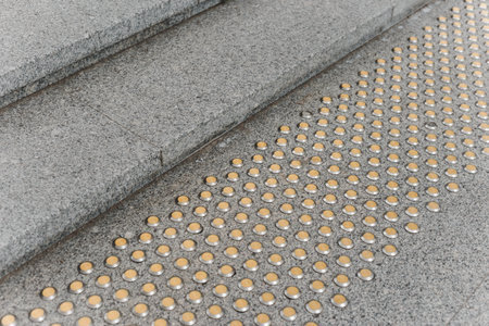 Stainless steel tactile indicators set set on walkway and stairs, closeup. Anti-slip surface.の写真素材