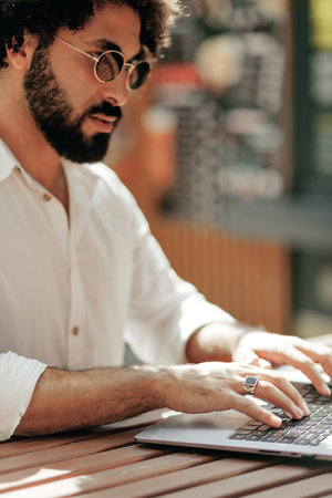 Freelancer man working with laptop in outdoors. Close up view on handsの写真素材