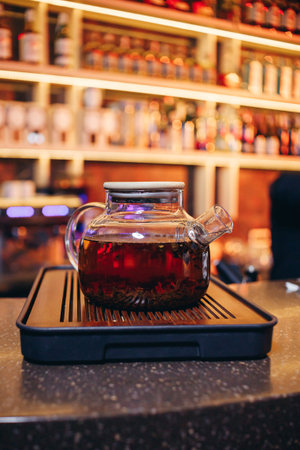 Traditional artisan tea in transparent teapot on bar counterの写真素材