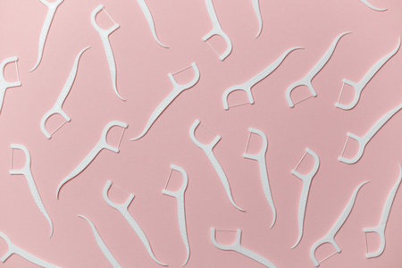 Dental floss with handle on pink background, flat layの写真素材