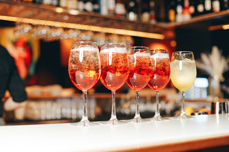 Aperol spritz being prepared on the bar in a cocktail bar.