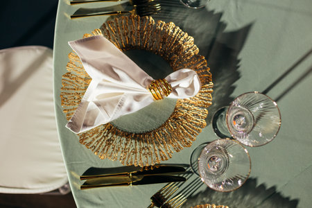 Top-down view of luxury table setting with gold charger plates and napkin ringsの写真素材