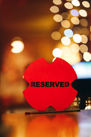 Red Reserved Sign On Wooden Table With Bokeh Background