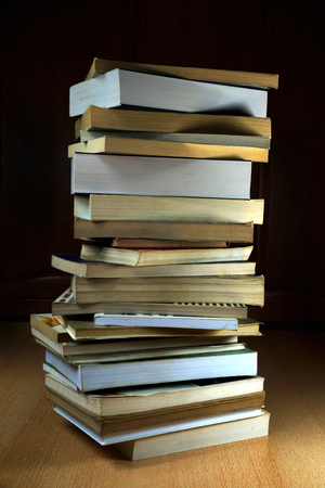 A table and a vertical stack of books on it, old and newの写真素材