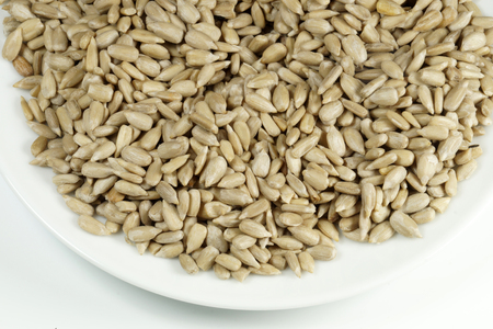 Shelled sunflower seeds on a white plateの写真素材