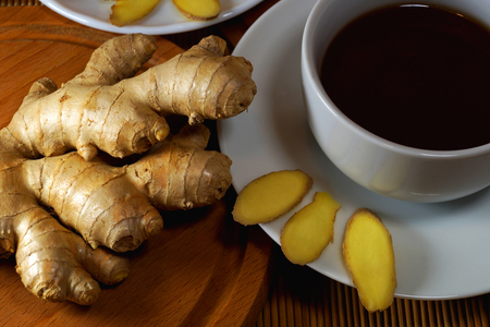 Ginger and tea, a tasty and healthy set, on a wooden boardの写真素材