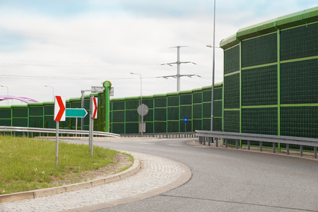 Departure from the local road to the highway. Noise wall that protect residents against noise generated by carsの写真素材