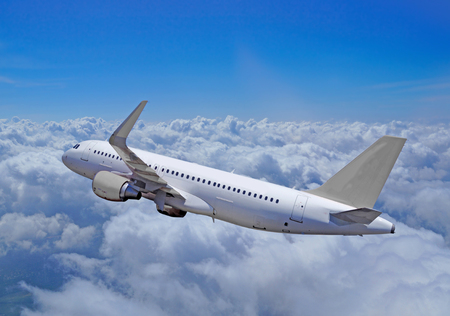 Gray passenger aircraft flies over clouds, the whole silhouetteの写真素材