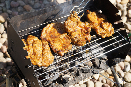 Grilled meat, barbecue, tongs, charcoal smoke. Turning meat to the other side.の写真素材