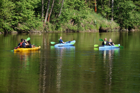 Summer, active rest. Three canoes while rafting along the wooded shore.の写真素材